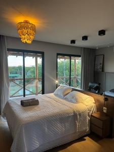 a bedroom with a large bed and a chandelier at Casa Aloha in Petrolina +38 photos