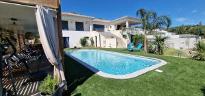 a swimming pool in the yard of a house at Villa Bistinetti Rez de villa tout confort avec piscine in Penta-di-Casinca