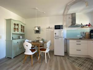 a kitchen with a table and chairs and a refrigerator at Fewo Herzgrün nähe Skilift & Loipe mit Sauna im Haus und Traumblick E-Ladestation in Todtnauberg