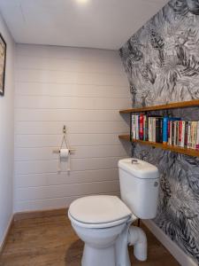 ein Badezimmer mit einer weißen Toilette und Büchern in der Unterkunft Maison auvergnate cœur de village in Messeix + 12 Fotos