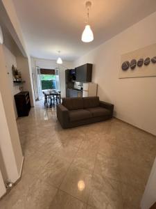 ein Wohnzimmer mit einem braunen Sofa und einer Küche in der Unterkunft Casa gioiello al mare Cogoleto in Cogoleto