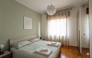 a bedroom with a bed with two towels on it at Il rifugio di Lilly & Mauri in Mereto di Capítolo