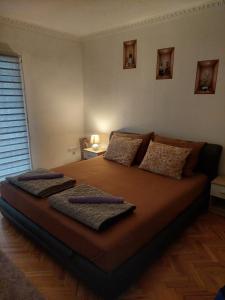 ein Schlafzimmer mit einem großen Bett und zwei Kissen darauf in der Unterkunft Apartman Time in Brčko