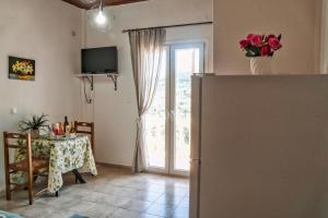 a living room with a table and a sliding glass door at Nana house 2 in Giannádes