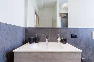 a bathroom with a white sink and a mirror at Loftino42 - Monolocale Open Space a Ferrara, Biciclette incluse in Ferrara +8 photos