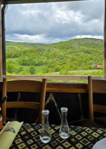 a table with two glasses and a view from a window at Apartman Harmonija Rent Zlatibor in Zlatibor +4 photos