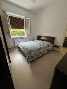 ein Schlafzimmer mit einem Bett vor einem Fenster in der Unterkunft Casa gioiello al mare Cogoleto in Cogoleto