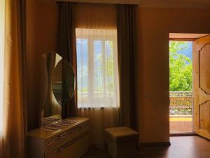 a mirror sitting on top of a dresser next to a window at Guesthouse in Lankhvri in Mestia