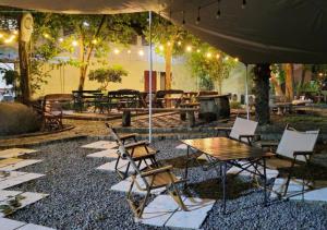 patio ze stołem i krzesłami pod namiotem w obiekcie Sand Paisan Resort w mieście Ban Tha Maprang
