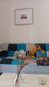 a vase with flowers on a table in front of a couch at Adorable apartment in Athens
