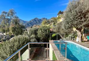 une maison avec une piscine et des montagnes dans l'établissement Villa Côte d'Azur piscine et spa, à Menton