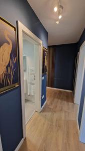a room with a hallway with blue walls and a door at Albert Garden Retreat in Ploieşti
