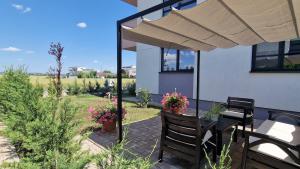 a patio with a table and chairs and an umbrella at Albert Garden Retreat in Ploieşti