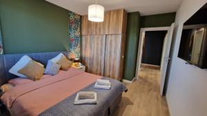 a bedroom with a large bed with two towels on it at Albert Garden Retreat in Ploieşti