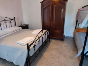 a bedroom with two beds and a wooden cabinet at B&B Da GIOVANNI in Masseria di Rusciano