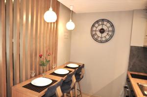 a dining room with a table and a clock on the wall at Mirma City apartment2 Old Town in Chania
