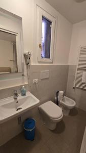 a bathroom with a sink and a toilet and a window at Venice Heart Rooms in Venice