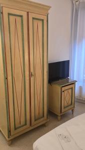 a bedroom with a bed and a cabinet with a television at Venice Heart Rooms in Venice
