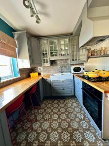 ダンガーバンにあるDog-friendly Seaview Apartmentのタイルフロアのキッチン(青いキャビネット付)