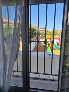 une fenêtre ouverte avec vue sur une aire de jeux dans l'établissement Extraordinaria Villa con piscina y chimenea, à Grenade