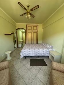 ein Schlafzimmer mit einem Bett und einem Deckenventilator in der Unterkunft Apartamento Hotel Cavalinho Branco in Águas de Lindóia + 25 Fotos
