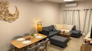 una sala de estar con una mesa y un sofá en Zephyr House Ocean View, Rooftop & Pool, en Grand Gaube
