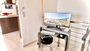 un écran d'ordinateur posé sur un bureau dans l'établissement Villa Côte d'Azur piscine et spa, à Menton