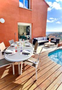 une salle à manger avec une table et des chaises sur une terrasse dans l'établissement Villa Côte d'Azur piscine et spa, à Menton