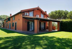 an orange house with a green lawn in front of it at Villa Orange Rome in Castel di Leva