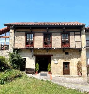 an old stone house with windows and a door at Posada de la Abadia - Adults Only in Santillana del Mar