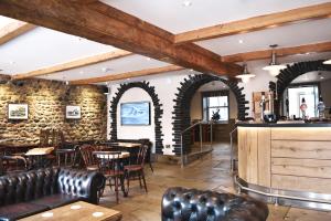 a restaurant with a bar and tables and chairs at The Morecambe Hotel in Morecambe