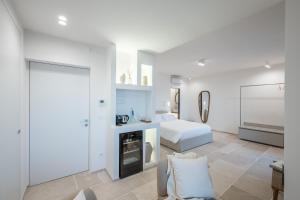 a white bedroom with a bed and a bedroom door at Trame Suites in San Vito Chietino