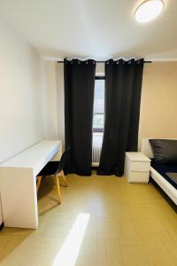 a room with a desk and a bed and a window at Helle 2-Zimmer Erdgeschosswohnung mit Terrasse in Koblenz