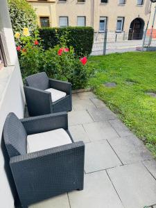 two wicker chairs sitting on a patio in a yard at Helle 2-Zimmer Erdgeschosswohnung mit Terrasse in Koblenz