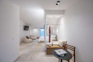 a living room with a table and a bedroom at Trame Suites in San Vito Chietino