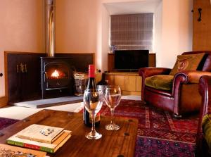 a living room with a bottle of wine and two glasses on a table at Mountain View Farm Cottage in Crickhowell