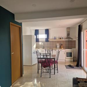 a kitchen with a table and chairs in it at Ylang maison au calme en campagne in Chaudron-en-Mauges