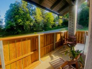 a porch with a wooden fence and two chairs at Villa Rose-Ruhige Ferienwohnung in Wien Nähe 