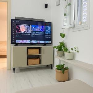 a flat screen tv on a stand in a living room at Marina Village in Herzliyya B
