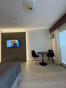 a bedroom with a bed and a table and a tv on a wall at Hotelli Terme, huone 617 in Ikaalinen