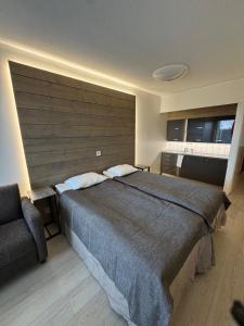 a bedroom with a large bed and a chair at Hotelli Terme, huone 617 in Ikaalinen