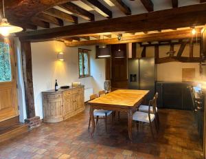 una cucina con un tavolo di legno e un frigorifero di Charming house surrounded by nature a Courtonne-la-Meurdrac Altre 15 foto