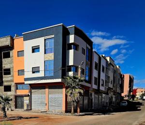 un edificio con una palmera delante en appartement moderne khenifra 2, en Khenifra 1 foto más
