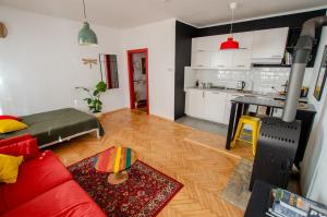a living room with a red couch and a kitchen at Studio na Średniej - Gliwice Old Town Studio Flat in Gliwice