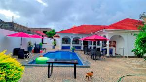 a house with a pool and a dog in front of it at The Gambian Princess in Sukuta