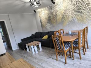a living room with a table and a black couch at Belle Apartament in Krapkowice