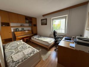 a bedroom with two beds and a desk and a desk at Sehr schöne Wohnung in 70839 Gerlingen in Deutschland in Gerlingen