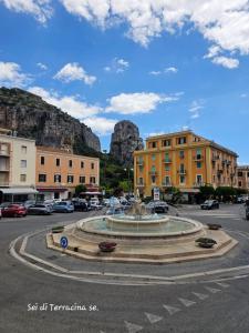 Una fuente en una ciudad con una montaña al fondo. en Moderni Appartamenti Appia Terracina, en Terracina