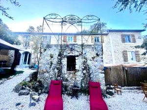 a stone building with two red benches in front of it at Haut villa Les Tilleuls 95 m2 7 pers in Carros