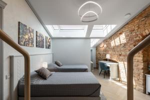 a loft bedroom with two beds and a desk at #stayhere - Modern Luxury Apartments in the Heart of Old Town Vilnius in Vilnius